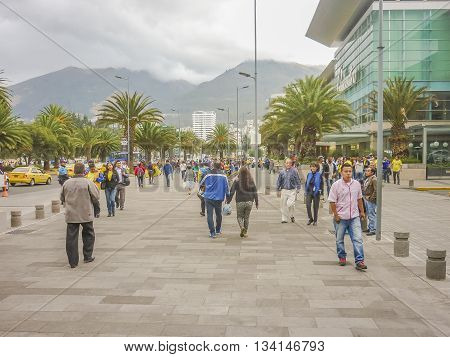 QUITO, ECUADOR, OCTOBER - 2015 - People walking at sidewalk with mountains at background in a modern downtown zone of Quito Ecuador
