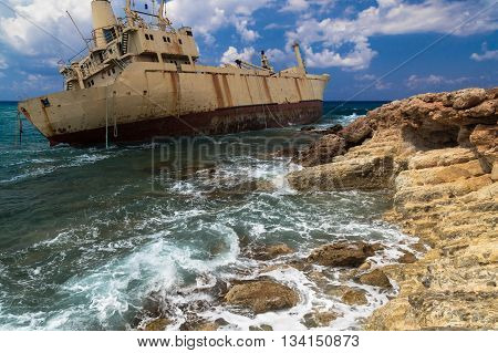 Seascape: boat shipwrecked near the rocky shore. Mediterranean near Paphos. Cyprus