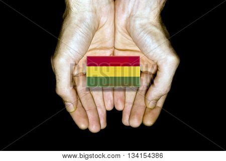 Flag of Bolivia in hands isolated on black background.