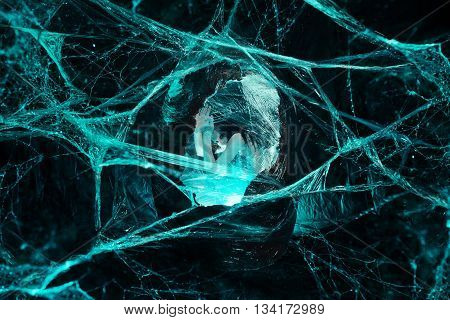 Woman sitting in big cocoon. Creative photoshoot