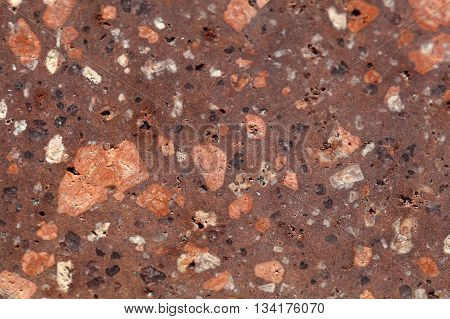Surface of a porphyry rhyolite rock from central Europe Saxony-Anhalt. The rock contains fragments of feldspars quartz and amphibole minerals in a fine grained matrix.