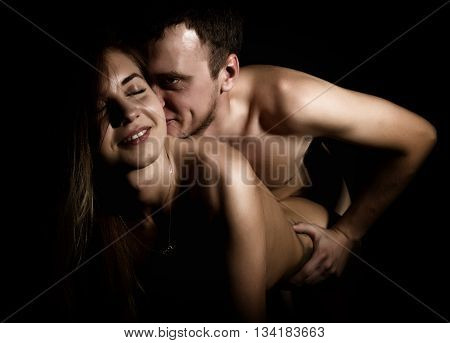 Close-Up Beautiful sexy young couple, naked man and woman on black background.