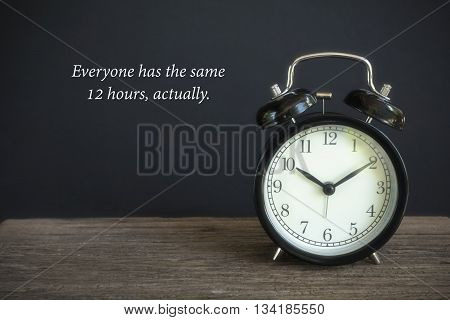 Alarm clock on wood with a black background. Concept of time with word 