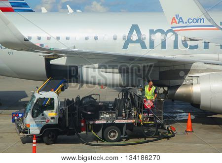 MIAMI, FLORIDA - JUNE 1, 2016: American Airlines worker refueling plane at Miami International Airport. American Airlines operates 274 flights every day from Miami