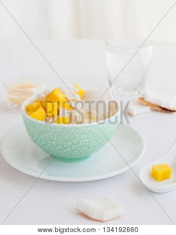 Rice pudding with mango and coconut water in a bowl, khao niaow ma muang White background Copy space Top view