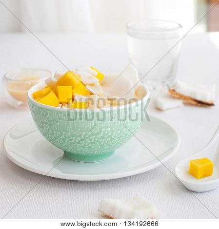 Rice pudding with mango and coconut water in a bowl, khao niaow ma muang White background Copy space Top view