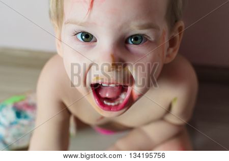 Closeup portrait of little screaming girl. Photo at home.