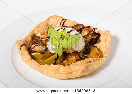 Apple pie with ice cream on a white plate