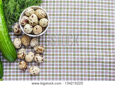 Quail eggs in a white bowl and a scattering of eggs and fresh herbs on a light background