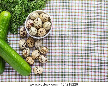 Quail eggs in a white bowl and a scattering of eggs and fresh herbs on a light background
