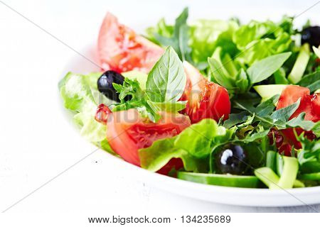 Tomato and cucumber salad with olives and pomegranate seeds