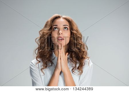The Woman is looking imploring over gray background