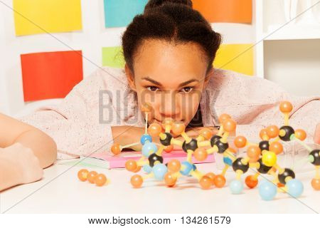 African student looking at the molecular model at the chemistry lesson