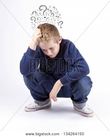 Sad preteen boy sitting on the floor holding his head many questions isolated on a white background. Thinking guy