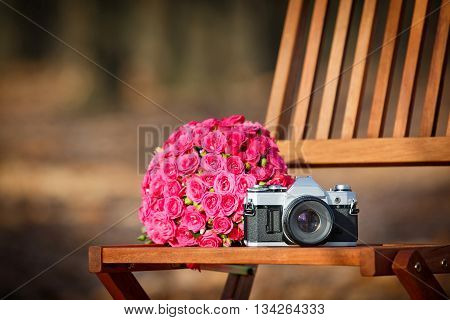 Сamera and wedding bouquet on a chair