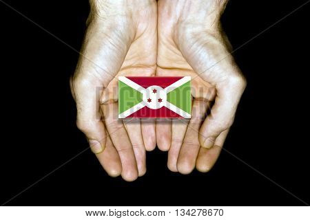 Flag of Burundi in hands isolated on black background.