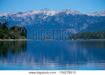 landscape of a lake with trees and mountains in the background