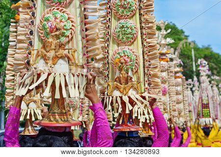 Beautiful Balinese women in traditional ethnic costumes - sarong carry offerings for Hindu ceremony. Arts festivals in Indonesia culture of Bali island and Indonesian people Asian travel background