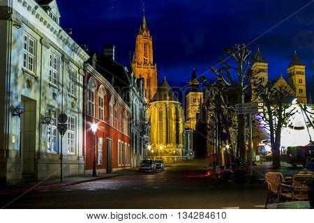 MAASTRICHT, NETHERLANDS - MAY 15, 2013: It is a night view of the illuminated red bell tower of St. Nicholas Church.