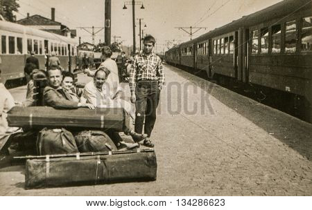 LODZ, POLAND, CIRCA 1960: Vintage photo of people with big luggage waiting for a train on platform