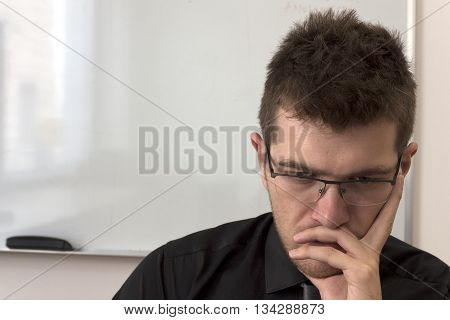 A businessman looking at monitor with serious look on his face