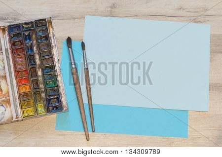 Old Watercolor Paintbox And Blue Pieces Of Paper
