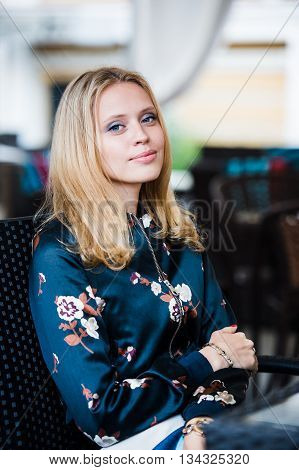 Young gorgeous European woman with pretty face thinking about something while sitting with laptop computer in cafe bar, dreamy beautiful female using portable net-book during work break in coffee shop.