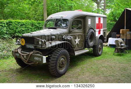 Silsoe, Bedfordshire, England - May 30, 2016: World War 2 American Ambulance with Red Cross parked in woods..