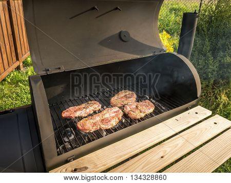 Pork butt chops being grilled on barbecue