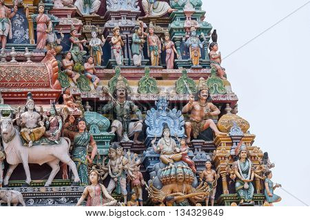 Chettinad India - October 17 2013:Detail of the Shiva temple gopuram at Kottaiyur shows Shiva and Parvati residing on Himalayan Kailash mountain on top of multi-headed Ravana. Combination of multiple colorful statues on Shiva temple gopuram.