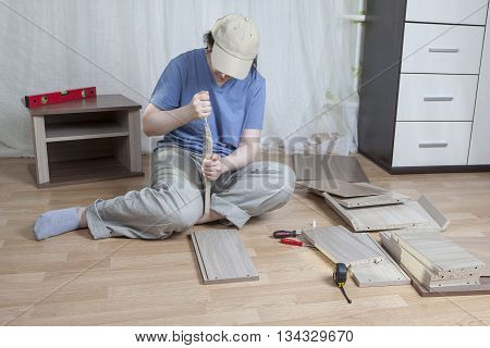 Assemble wooden furniture woman putting together self assembly furniture.
