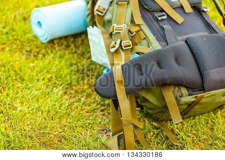 Hiking backpack camping and mountain exploring tourist equipment outdoor on grass. Adventure summer tourism active lifestyle