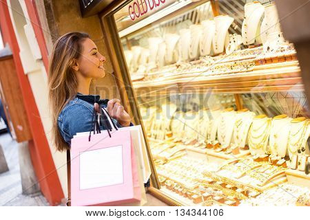 young woman looking at jewellry in a shop window
