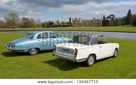 Saffron Walden, Essex, England - April 24, 2016: Two Classic cars in front of stately home, a Triumph Herald Convertible and a Jaguar.