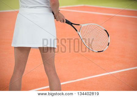 Athlete playing tennis with a racket against composite image of tennis field