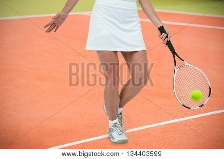 Athlete playing tennis with a racket against composite image of tennis field