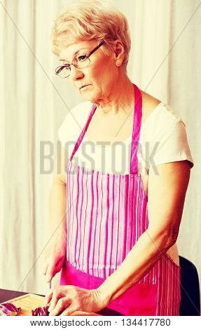 Woman cut red onion on cutting board