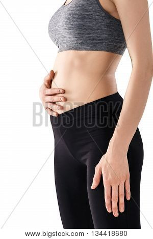 Sporty beautiful young woman practicing Uddiyana Bandha technique isolated on white