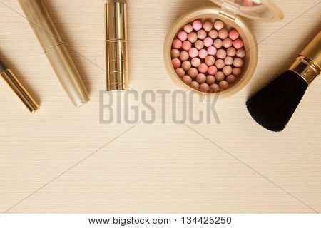 Golden Cosmetics - Mascara, Lipstick, Powder, Blusher, Brush Pencil On Light Wooden Background With