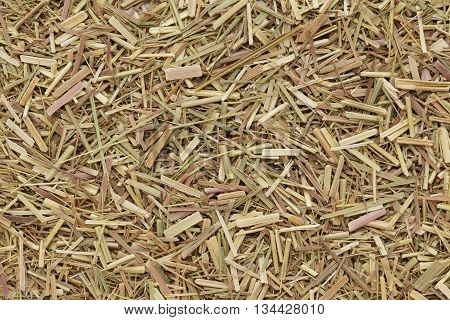 Organic dry lemongrass (Cymbopogon flexuosus) tea cut. Macro close up background texture. Top view.