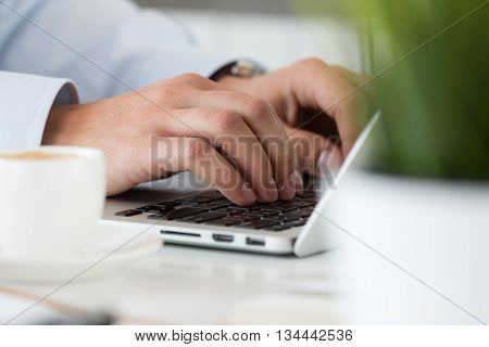 Close up view of businessman designer or student hands working on laptop. Online distant education writing blog freelance mobile payments working at office or at home concept.