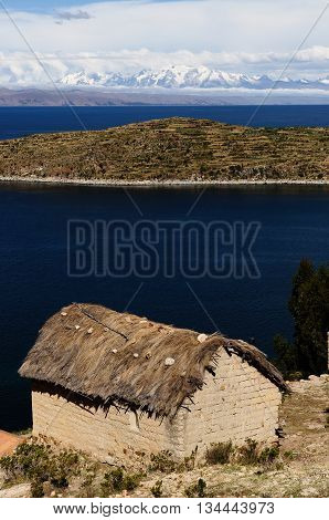 South America Bolivia - Isla del Sol on the Titicaca lake the largest highaltitude lake in the world. Traditional house built of clay relating to snowy mountains