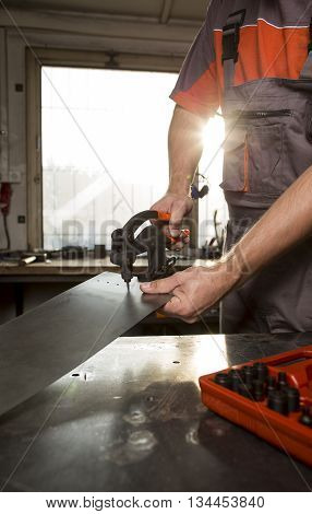 Male worker holding the heavy manual punch