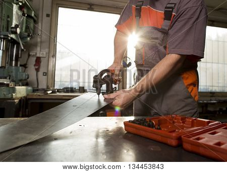 Male worker holding the manual punch inside
