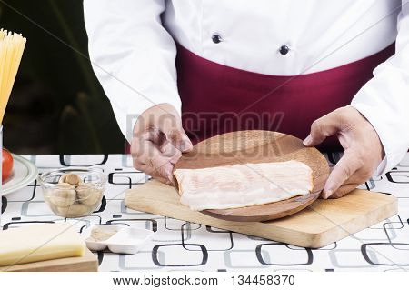 Chef present bacon for cooking spaghetti carbonala / cooking spaghetti concept