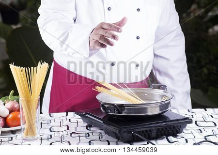 Chef putting spaghetti to boiled in the pan / cooking spaghetti concept