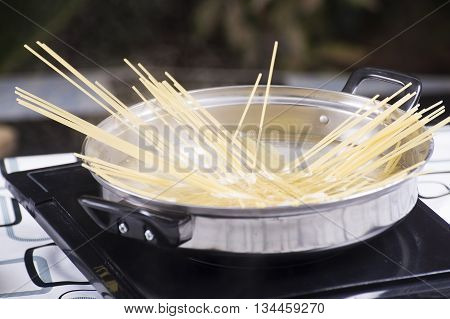 Closed up spagetti boiling in the pan / cooking spagetti concept
