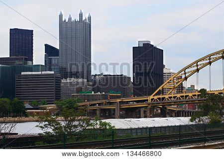 Skyline of downtown Pittsburgh Pennsylvania. Administrative and high rising office buildings. Visible is Monongahela River with moored transport barge bridges and Highways.