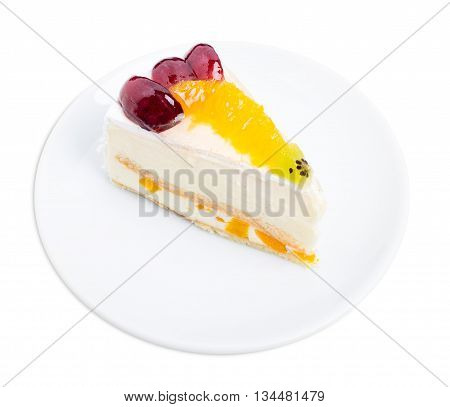 Creamy yougurt mousse cake with fruits on top. Isolated on a white background.