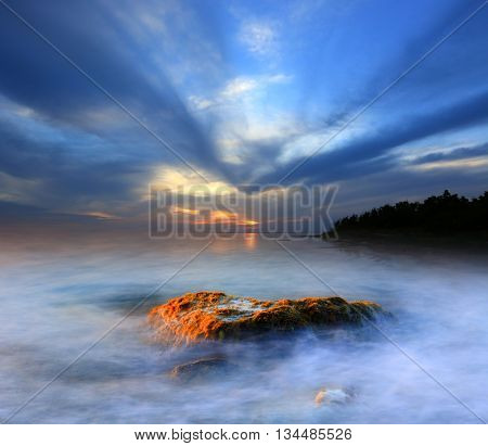 Evenign landscape with old stones in lake water